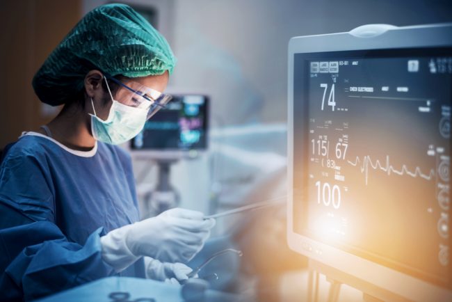 Team,Of,Doctors,Or,Surgeons,With,Electrocardiogram,Monitor,In,Hospital